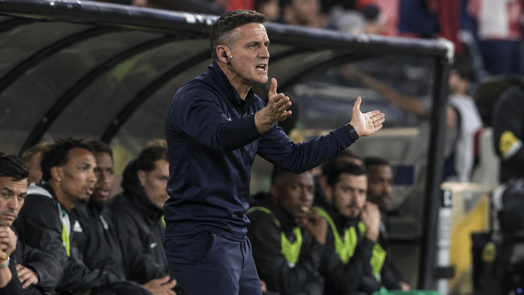 John Herdman memberikan instruksi taktik agresif kepada para pemain Timnas Indonesia di pinggir lapangan.